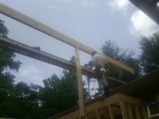 Carpenter setting a ridge beam over a new addition frame — Ice Dam Removal by Roofing Brothers in Alta