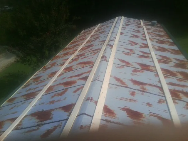 Rusted metal roof panels with new wood purlins before replacement — Storm Damage Roof Repair in Alta by Roofing Brothers
